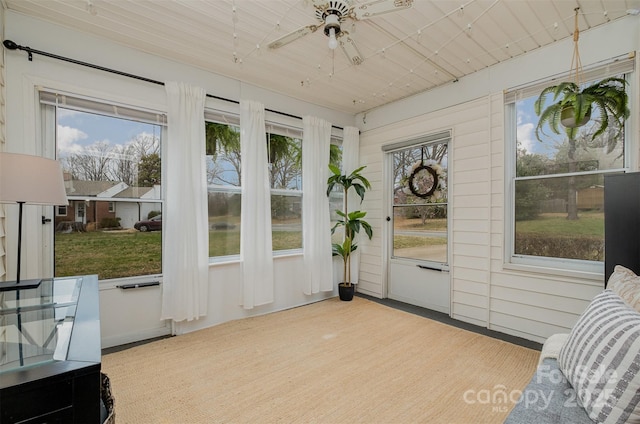 sunroom / solarium featuring wood ceiling and a ceiling fan