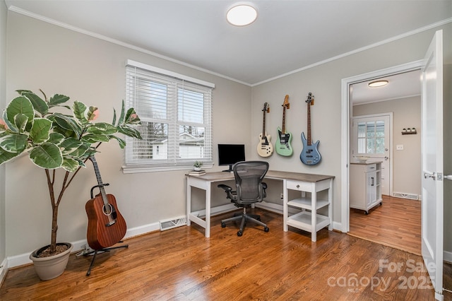 office area featuring visible vents, baseboards, wood finished floors, and ornamental molding