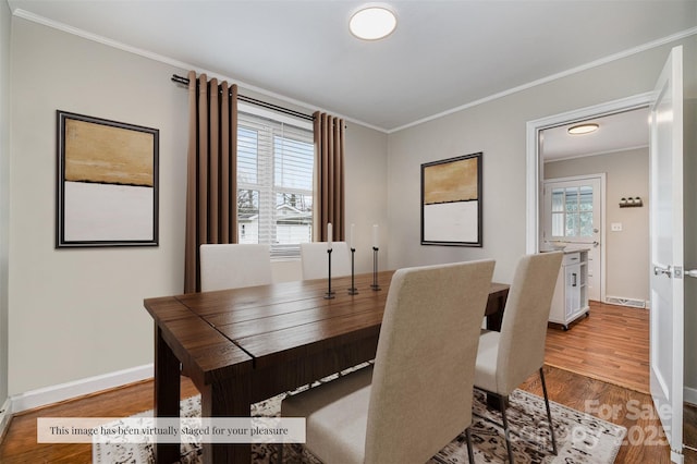 dining area with crown molding, wood finished floors, baseboards, and visible vents