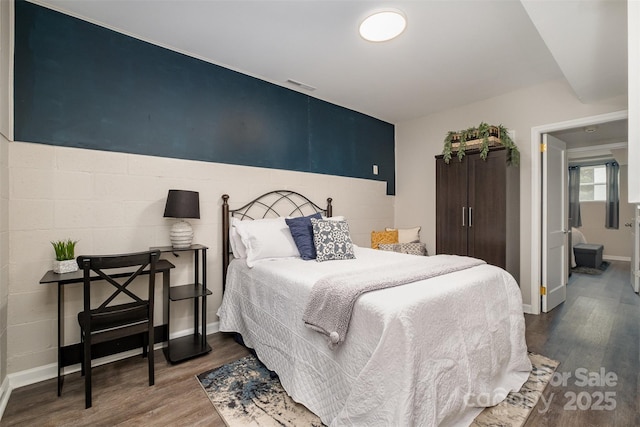 bedroom featuring visible vents, baseboards, and dark wood-type flooring