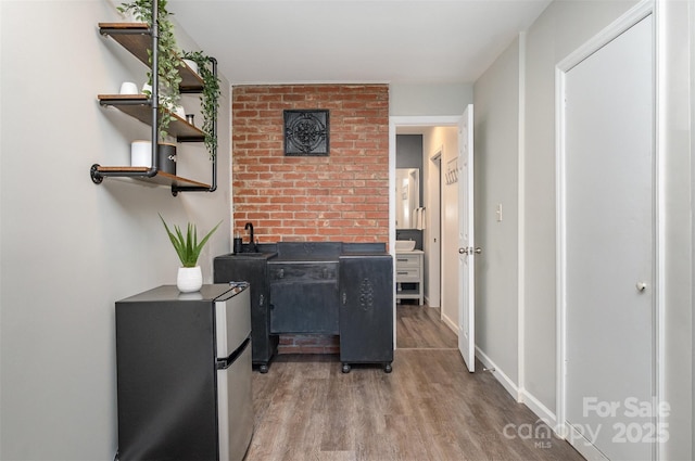 hall with baseboards and wood finished floors