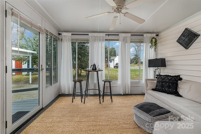 sunroom / solarium with a ceiling fan