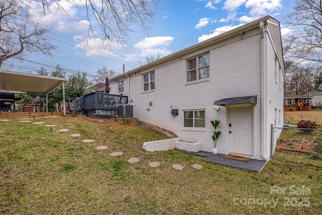 back of house featuring a deck, fence, a yard, brick siding, and central AC unit