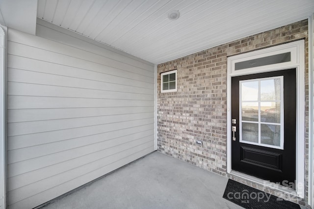 doorway to property featuring brick siding