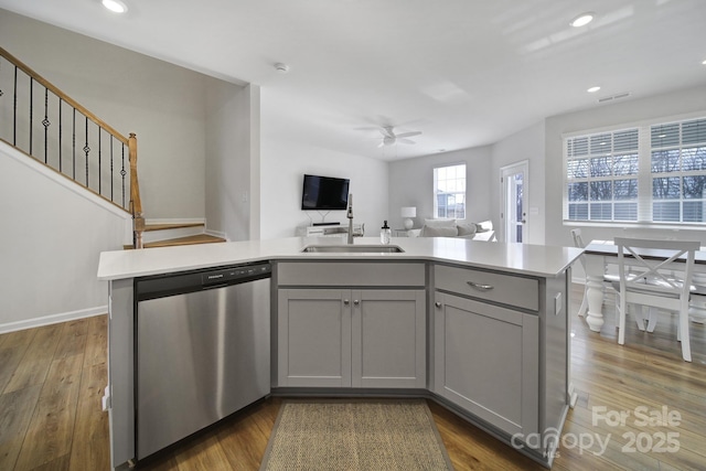 kitchen featuring gray cabinets, a sink, light countertops, dishwasher, and open floor plan