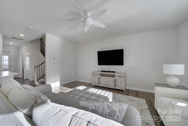 living area with visible vents, baseboards, stairs, dark wood-style floors, and a ceiling fan