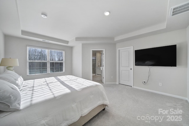 bedroom featuring visible vents, baseboards, a tray ceiling, and carpet floors