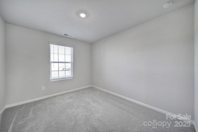 unfurnished room featuring visible vents, carpet, and baseboards