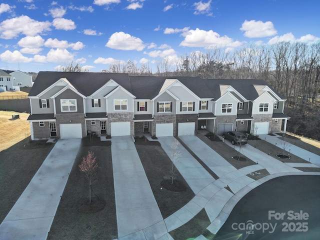 view of front of property featuring a residential view, an attached garage, and concrete driveway