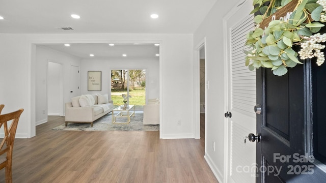 foyer with baseboards, wood finished floors, visible vents, and recessed lighting