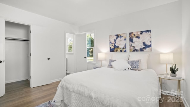 bedroom with a closet, baseboards, and wood finished floors