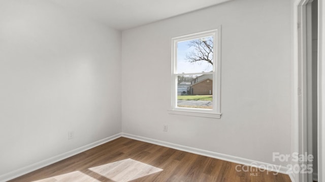 unfurnished room with baseboards and wood finished floors