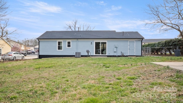 back of house featuring a lawn, fence, and central air condition unit