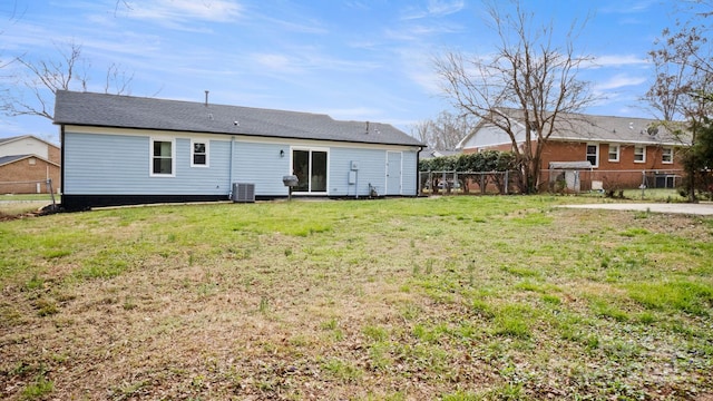 rear view of property with a lawn and fence