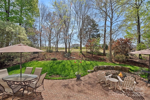 view of yard with a patio, outdoor dining area, and a fire pit