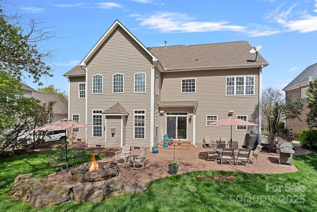rear view of house featuring an outdoor fire pit, a patio area, crawl space, and a lawn