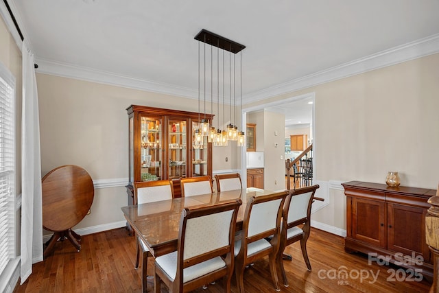 dining area with an inviting chandelier, crown molding, and dark wood finished floors