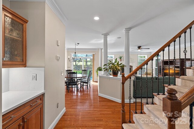 interior space with baseboards, recessed lighting, stairs, light wood-style floors, and decorative columns