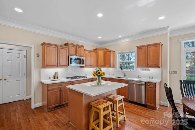 kitchen featuring light countertops, brown cabinets, a sink, and appliances with stainless steel finishes