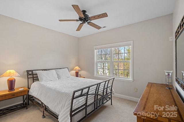 carpeted bedroom with visible vents, baseboards, and a ceiling fan