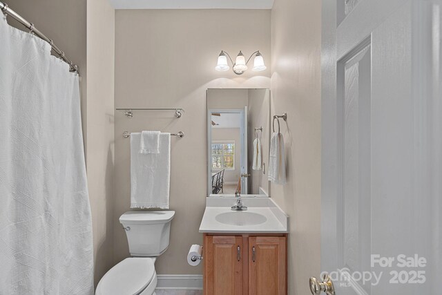 full bathroom featuring toilet, curtained shower, vanity, and baseboards