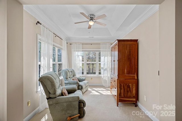 sitting room with baseboards, a raised ceiling, a ceiling fan, crown molding, and light carpet