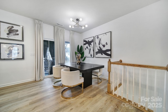 dining space featuring visible vents, light wood-style flooring, baseboards, and an inviting chandelier