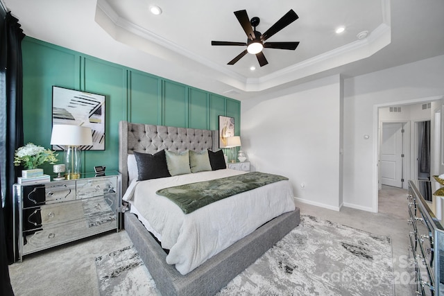 bedroom featuring a raised ceiling, light colored carpet, crown molding, a decorative wall, and recessed lighting