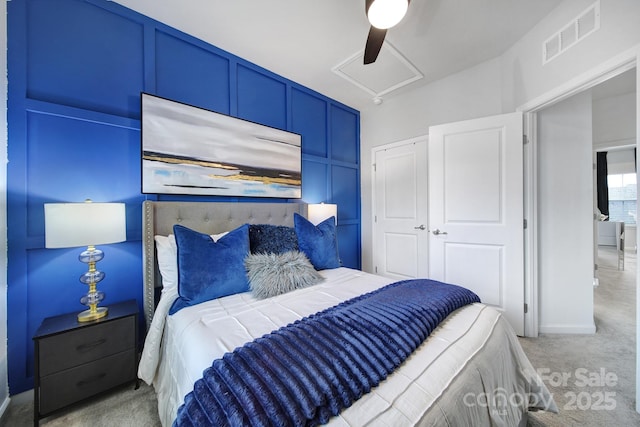 bedroom featuring carpet floors, a ceiling fan, visible vents, and attic access