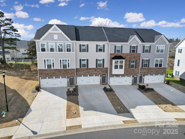 view of property featuring board and batten siding, driveway, a shingled roof, and an attached garage