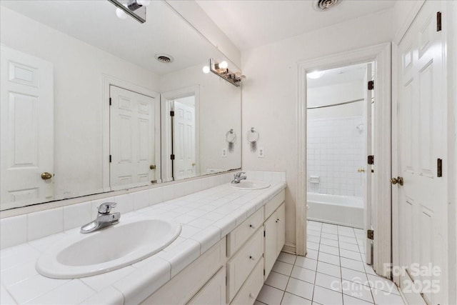 full bathroom with double vanity, visible vents, a sink, and tile patterned floors