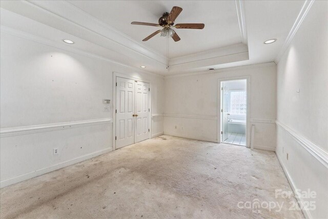 carpeted empty room featuring crown molding, recessed lighting, a raised ceiling, ceiling fan, and baseboards