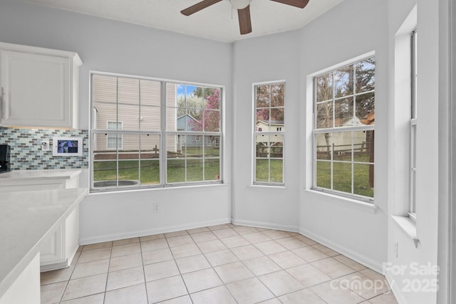 unfurnished sunroom featuring a ceiling fan