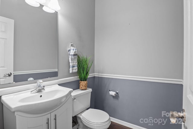 bathroom featuring baseboards, toilet, and vanity