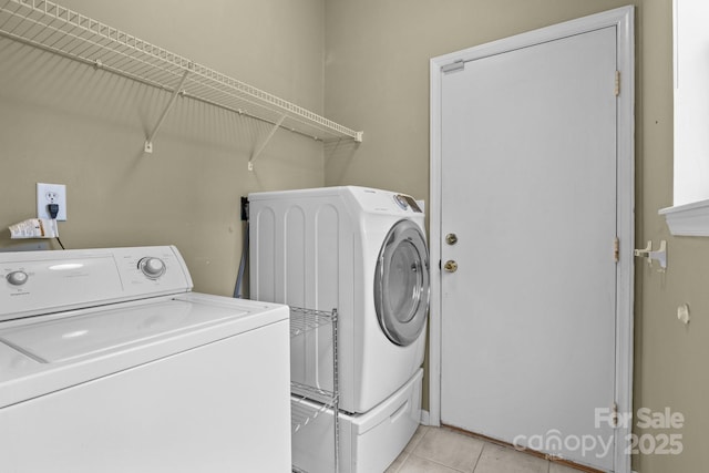 laundry area featuring light tile patterned floors, washing machine and dryer, and laundry area