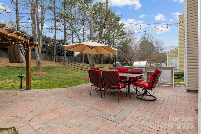 view of patio featuring grilling area, an outdoor kitchen, outdoor dining area, and fence