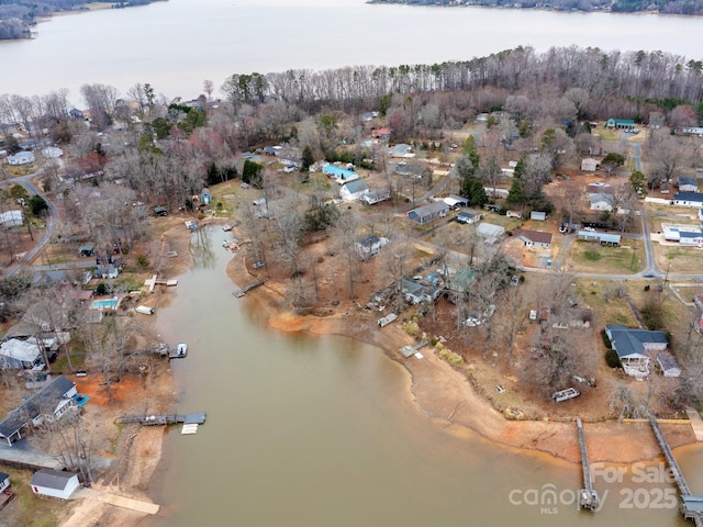 birds eye view of property with a water view and a view of trees