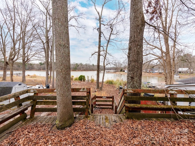 exterior space with an outdoor structure, fence, a water view, and a shed