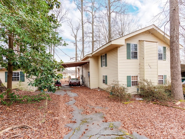 view of side of property featuring a carport and driveway