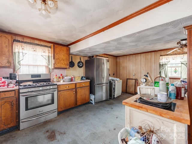 kitchen with brown cabinetry, a healthy amount of sunlight, stainless steel appliances, and light countertops