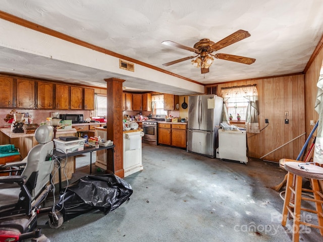 interior space with visible vents, wood walls, freestanding refrigerator, and a ceiling fan