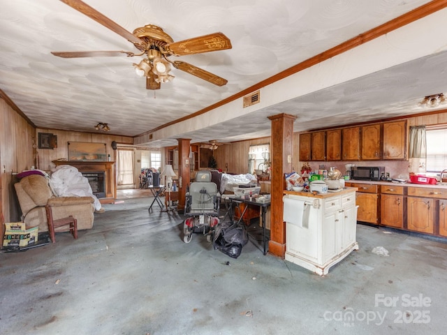 garage featuring visible vents, wood walls, and ceiling fan