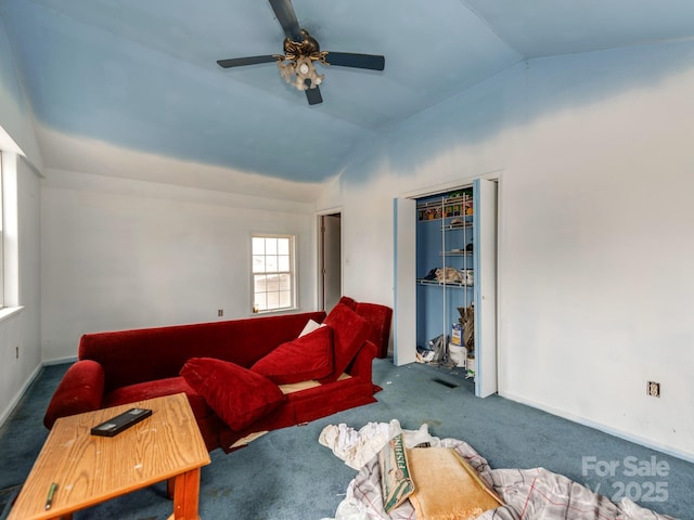 carpeted living area featuring ceiling fan, baseboards, and lofted ceiling