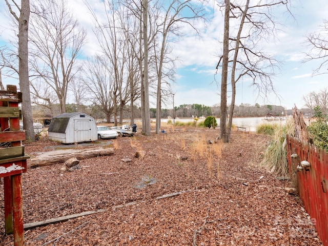 view of yard featuring a storage unit, an outdoor structure, and a water view