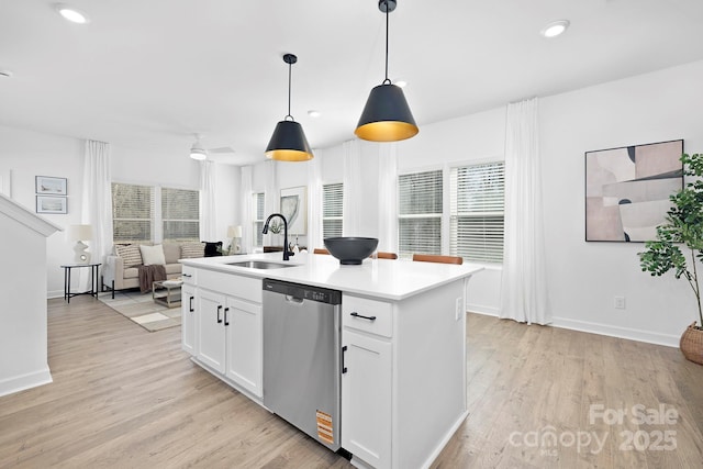 kitchen with a sink, white cabinets, open floor plan, light wood-style floors, and dishwasher