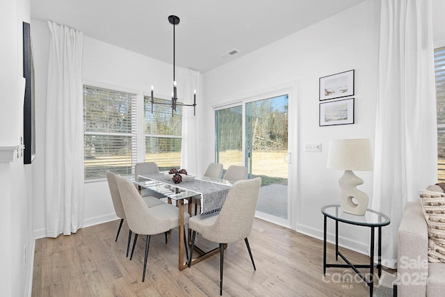 dining room featuring baseboards, an inviting chandelier, and wood finished floors