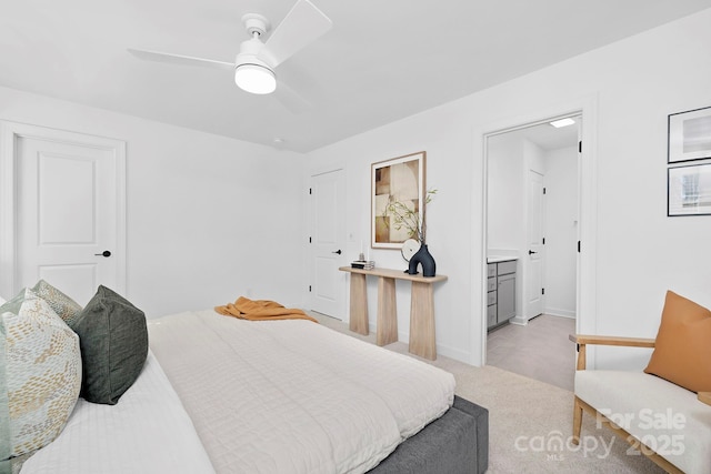 bedroom with light carpet, ceiling fan, baseboards, and connected bathroom