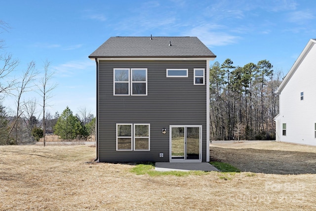 rear view of house featuring roof with shingles and a patio area