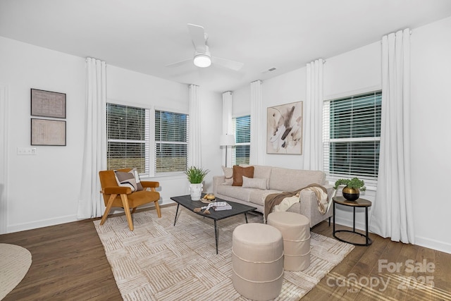 living room featuring ceiling fan, baseboards, and wood finished floors