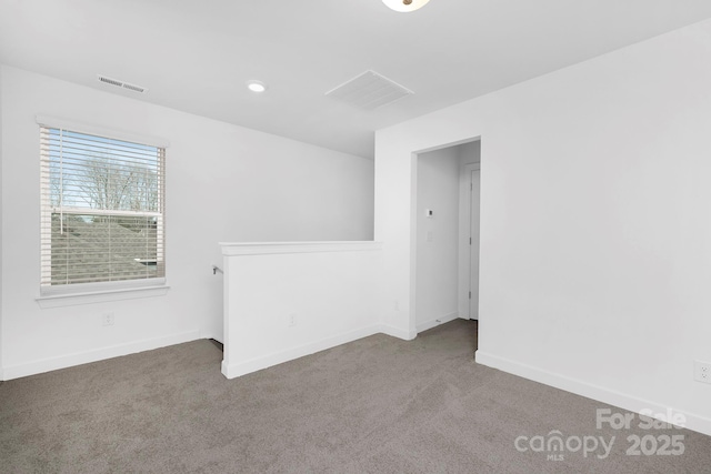carpeted empty room with visible vents and baseboards